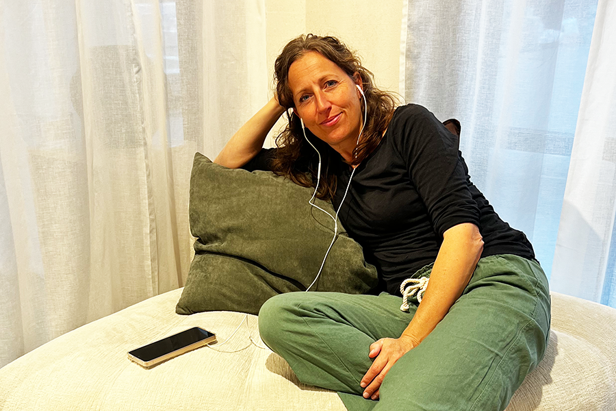 Jeannine Maurer sitzt abends bei warmem Licht auf dem Sofa und atmet ruhig